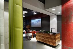 View of exotic-wood kitchen island and dining area with retro swivel chairs in open-plan kitchen