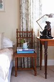 Antique, carved chair next to dog ornament on table