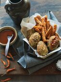 Crab cakes with sweet potato fries in a wooden basket with a dip