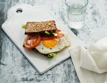 A wholemeal sandwich with fried egg and tomatoes