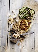 Grilled vegetables (avocado and garlic), almonds and lemons on a chopping board