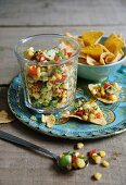 Sweetcorn and avocado salsa with limes and tomatoes served with tortilla chips