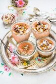 Mini cheesecakes in glass bowls with strawberries and meringues