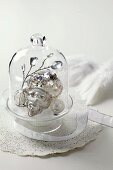 Silver Christmas decorations under glass cover