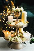 Lit candles and white roses on cake stand