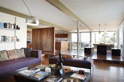 View from lounge area into dining area and open-plan kitchen on platform behind partition