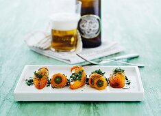 Stuffed yellow pointed peppers served with a beer