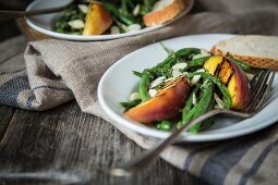 A green bean salad with grilled peaches and flaked almonds