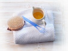 A towel, a brush and a jug of oil
