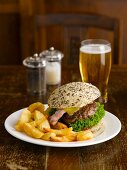 A hamburger with chips and beer in a pub