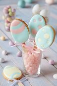 Egg-shaped biscuits on stick with pastel-coloured icing