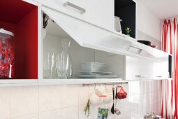 White wall cupboards with an open door in a renovated kitchen