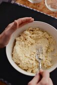 Gnocchi dough being mashed with a fork