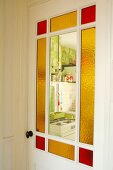 Vintage-Zimmertür mit teilweise farbigen Glasfüllungen, Blick in die Küche
