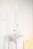 White interior: lit candles in romantic candelabra on plant stand