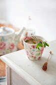 Peppermint tea with a bundle of herbs for stirring