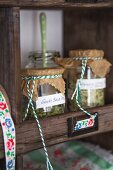 Home-made herb salts in preserving jars on dresser shelf