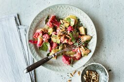 Pink cauliflower and avocado salad with pine nuts (seen from above)