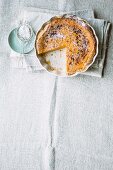 Pumpkin and apple tart with icing sugar, sliced