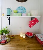 weiße Wandkonsole mit pastellfarbenen Aufbewahrungsdosen in Landhausküche