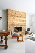 Seating area in eclectic mixture of styles; rustic chimney breast, retro armchairs and various side tables