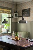 Retro pendant lamp with chrome lampshades above solid-wood table in corner of dining room