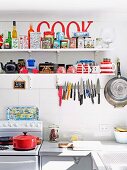 Küchenregal mit Blechdosensammlung und Magnetschiene mit Messern in einfacher Küche mit Retroflair