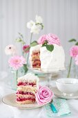 Festive raspberry cake with buttercream, whipped cream and pink roses