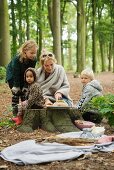 Family having autumn picnic in woods