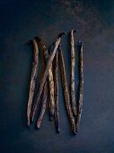 Vanilla pods on a dark surface