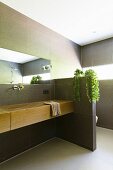 Modern gefliestes Bad mit elegantem Holzwaschtisch und Sichtschutzwand zum Toilettenbereich