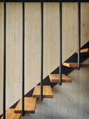 Detail of staircase with wooden treads and black metal balustrade