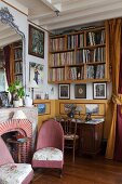 Klassisches Wohnzimmer mit Bücherwand, antiken Möbeln und Kamin