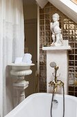 Bathtub with vintage-style tap fittings and white cherub on masonry shelf in renovated interior