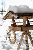 Wreath of peanuts hung from bird table