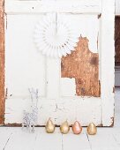 Gold and copper pear ornaments and white reindeer in front of shabby-chic wooden wall