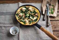 A spinach and mushroom omelette in the pan