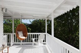 Classic Scandinavian design: wicker hanging chair by Nanna Ditzel on white veranda