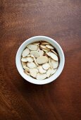 Flaked almonds in a porcelain bowl (seen from above)