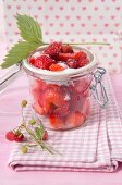 Strawberries and wild strawberries in preserving jar with sugar