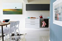 Bright, open-plan kitchen with floating base cabinets and dining area in foreground