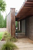 Veranda with sculptural wooden elements and glass door