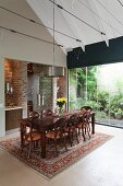 Elegant dining table on Oriental rug in high-ceilinged modern interior