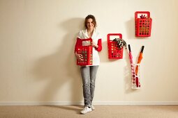 Woman holding basket in hands next to identical red baskets hung on wall