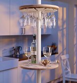 Round minibar with wine glass rack on telescopic pole in kitchen