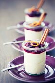 Marzipan mousse with mulled wine cherries in glasses garnished with orange zest and cinnamon sticks