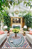 Coffee table with ornate tile top and sofa set in interior with glass roof