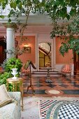 Plants in conservatory opening into lounge with chequered tiled floor and row of columns