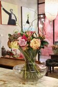 Blumenstrauss mit Weidenzweigen in Glasvase auf Vintage Holzablage