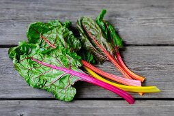 Swiss chard with stalks of various colours on wooden surface